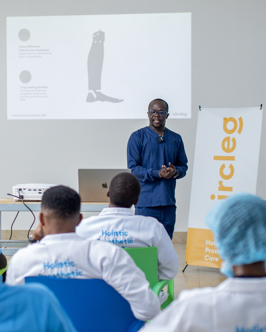 A Kenyan prosthetist is training a group of African orthopaedic and prosthetic technicians. In the background you see the fake leg, circleg.
